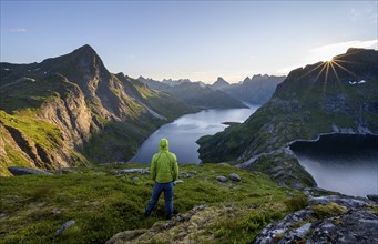 Mountaineer looking over mountain landscape with pointed mountain peaks and fjord Forsfjorden with