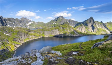 Mountain landscape with lake Tennesvatnet, at sunrise, in the back peak of Hermannsdalstinden,