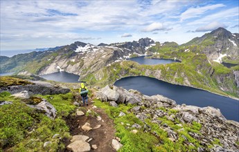 Mountaineers on a hiking trail, mountain landscape with steep rocky mountain peaks and lake