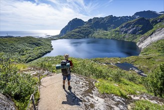 Mountaineers on the hiking trail to Munkebu hut, view of lake Stuvdalsvatnet, Moskenesoya, Lofoten,