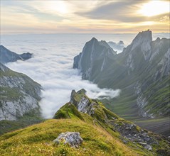 View over Säntis mountains into the valley of Meglisalp at sunrise, Rotsteinpass, high fog in the