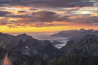 View over mountain top and sea to Fredvang, dramatic sunset, from the top of Hermannsdalstinden,