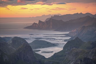 View over mountain top and sea to Fredvang, dramatic sunset, from the top of Hermannsdalstinden,