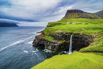 Gasadalur waterfall into the ocean, Vagar, Faroe islands, Denmark, Europe