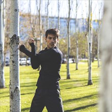 Young man stretching arms before jogging