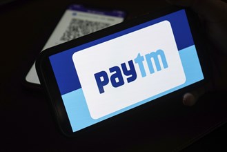 In this photo illustration, the Paytm logo and PhonePe QR code, is seen displayed on mobile phones