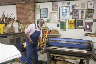 Detroit, Michigan, Amos Kennedy works in his letterpress printing shop. Kennedy prints posters and