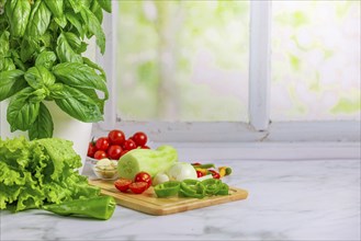 Fresh vegetables on a board, salad ingredients, peeled cucumber, tomatoes, lettuce, basil,