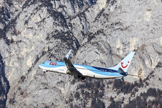 TUI airline aircraft taking off at Innsbruck Kranebitten Airport, Boeing 737-800. Snow-covered