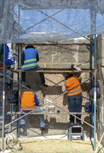 Workers maintaining stonework Eagles and Jaguars platform, Chichen Itza, Mayan ruins, Yucatan,