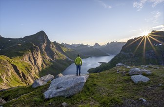 Mountaineer looking over mountain landscape with pointed mountain peaks and fjord Forsfjorden with