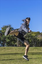 Martial fighter practicing flying kicks. Copy space