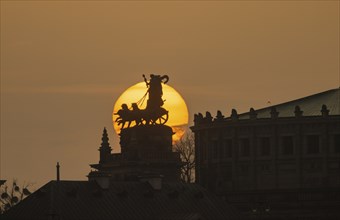 Sunset in Dresden. The sun's disc, particularly orange due to the Sahara dust, sets behind the