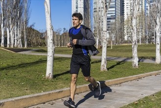 Young attractive athlete sportsman runner jogging in the morning in public park