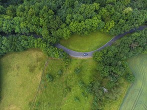 Winding country road with car near Wildenfels in the Ore Mountains