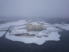 Snowfall over Moritzburg Castle on its distinctive pond island