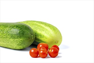 Field cucumbers (Cucumis sativus) and cocktail tomatoes (Solanum lycopersicum), on white, copy room