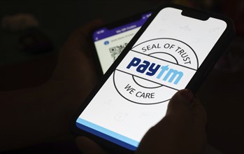 In this photo illustration, the Paytm logo and PhonePe QR code, is seen displayed on mobile phones