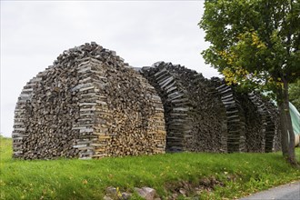 Split wood stacked for rent to dry better. Wood is becoming increasingly popular as a heating