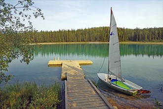 Small boat and jetty on a lake with crystal clear water, Boya Proinvial Park, Stewart Cessiar