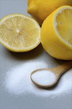 Citric acid in wooden spoon and lemon