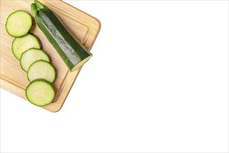 Courgettes (Cucurbita pepo), cut open, on wooden board, on white, copy room