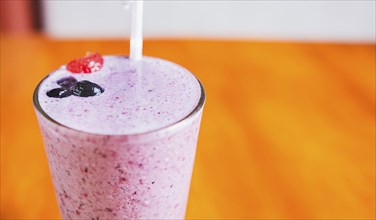 Close up of a strawberry milkshake in blurred background with copy space. Strawberry smoothie with