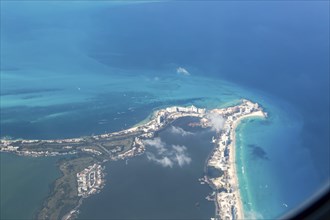 Aerial view through plane window of Caribbean coastline buildings in the hotel zone, Cancun,