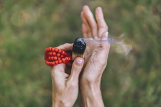 Top angle view of a palo santo or a holy sacred tree stick, burning with aroma smoke held by