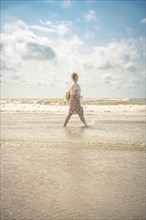 Woman on the beach in the evening sun, Zandvoort, Netherlands