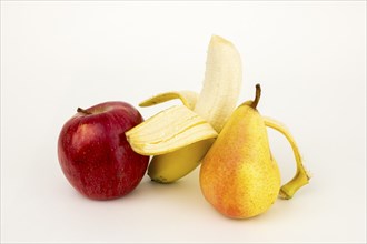 Half peeled banana with apple and pear, studio shot, white background, healthy food