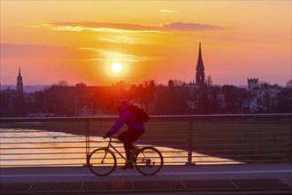 Evening sky over the Elbe with cyclist and tower of the Martin Luther Church seen from the