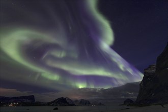 Northern Lights (Aurora borealis) in green and blue over the beach of Haukland, Lofoten, Norway,