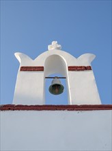 Low-angle view of whitewashed belfry wiith blue sky in background, Ia, Oia, Santorini, Greece,