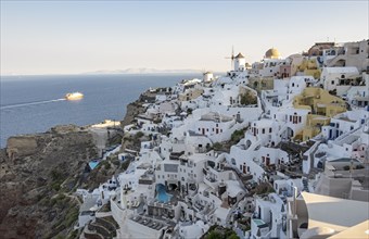 Cliff-side houses, villas and windmill in the village of Oia, Ia, as seen from the Kasteli Castle,