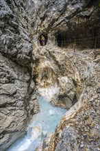 Hiker in a gorge, Hammersbach flows through Höllentalklamm, near Garmisch-Partenkirchen,