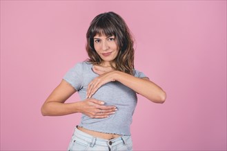 Woman doing a Breast Self-Exam (BSE) while looking at camera