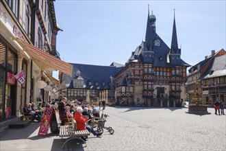 Tourists sitting outside a restaurant at the market place, town hall, Wernigerode, Harz Mountains,