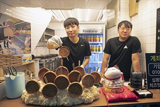 Korean man, 26, showing a mozzarella pancake, Gwangjang market, traditional street market in