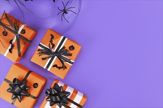 Gift boxes with traditional Halloween event colors orange, black and white and small bats and