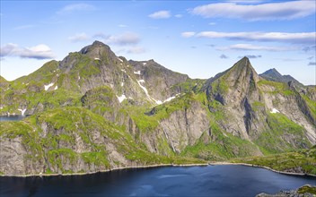 Mountain landscape with lake Tennesvatnet and steep rocky mountain peak with waterfall, peak of