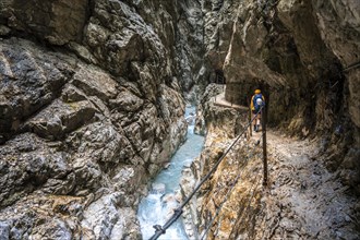 Hiker in a gorge, Hammersbach flows through Höllentalklamm, near Garmisch-Partenkirchen,