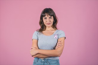 Serious woman wearing pink breast cancer awareness ribbon