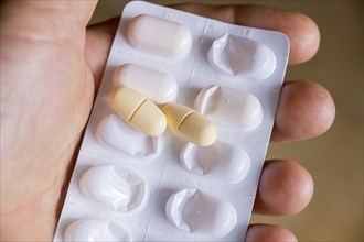 Hand holding a blister pack with tablets