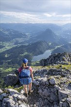 Mountaineer at the summit of the Scheffauer, view of Hintersteiner See and Inntal, Kaisergebirge,