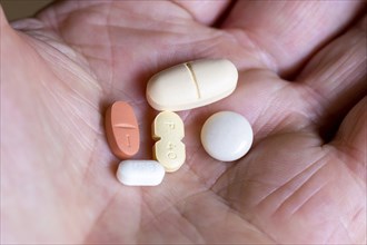 Hand holds various tablets, medicines