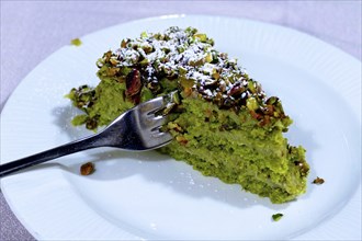 Piece of pistachio cake on white plate, detail, Catania, east coast, Sicily, Italy, Europe