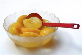 Peach, pickled peach halves in glass bowl with ladle