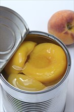 Peach, preserved peach halves with syrup in a tin can