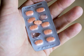 Hand holding a blister pack with tablets